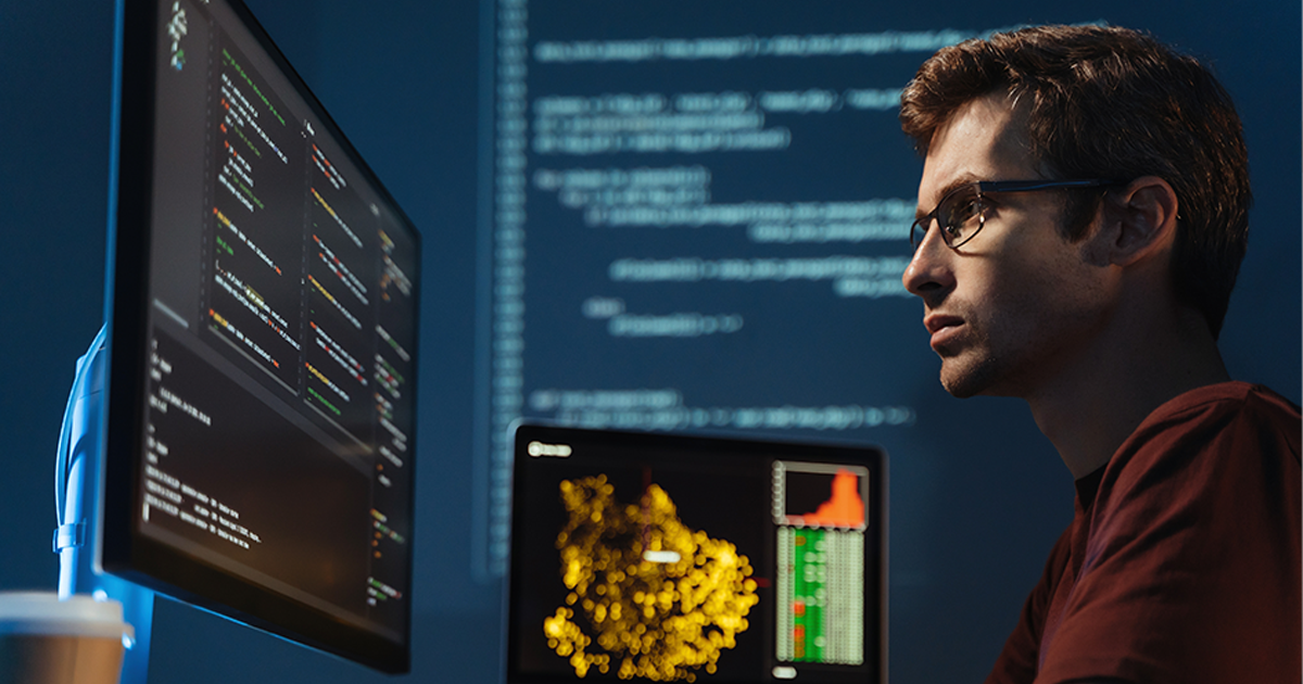 Programmer man looking at big monitor checking id-address and debugging system, writing html code