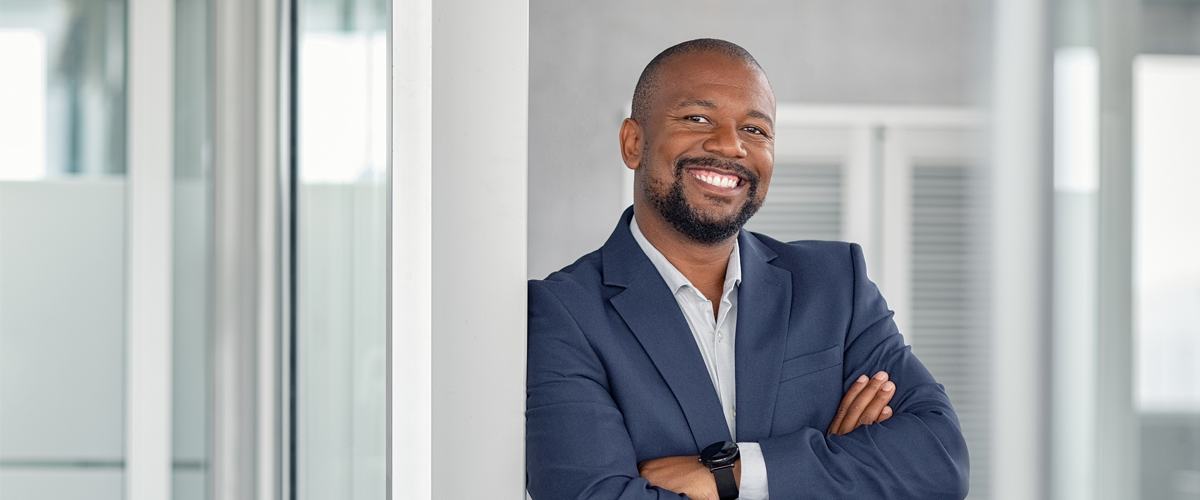 Mature cheerful african american executive businessman at workspace.