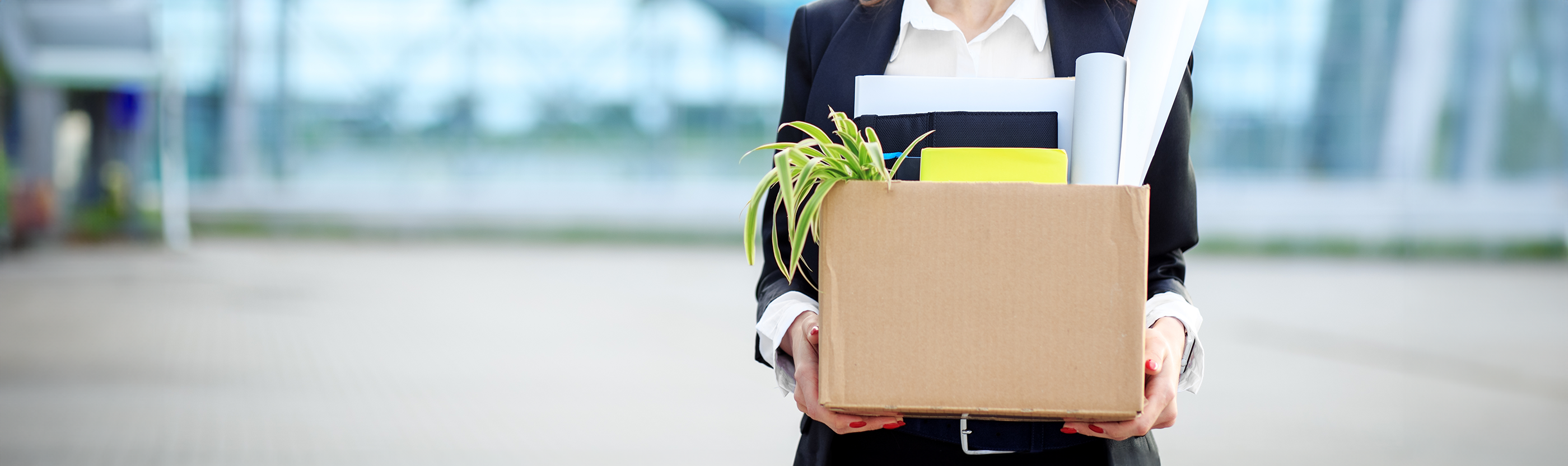 Woman leaving job with a box of personal items.