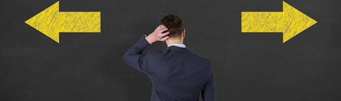 Confused businessman - people feeling confusion and chaos. Indecisive, disorientated and bewildered man stressed with headache over decision making. Young Man on blackboard background