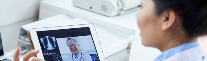 doctor using tablet to talk to another doctor