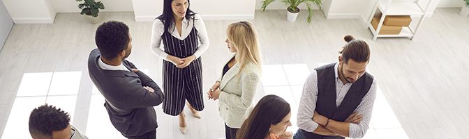 A group of business owners stand around an event networking.