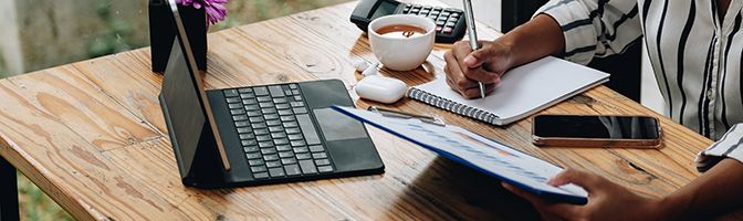 A small business owner goes over financial records at an office desk.