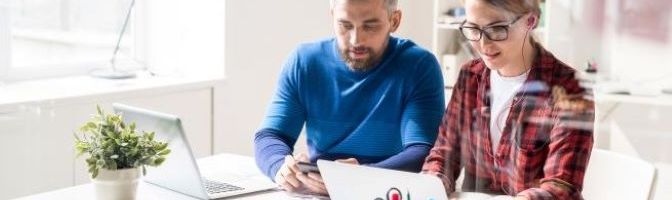 Man and Woman viewing a laptop at office desk