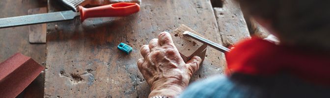 close up of someone using a chisel on a block of wood