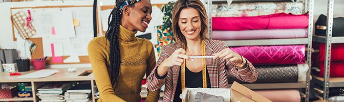 Two small business owners taking a photo of merchandise to sell online.