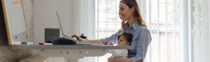 woman working at desk with baby on lap