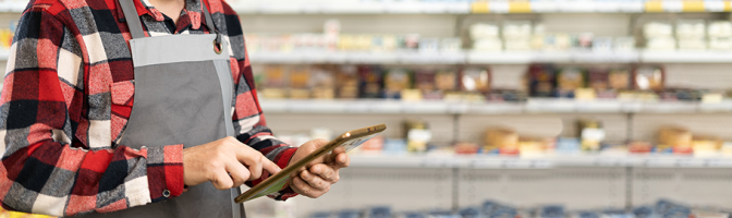 supermarket clerk using apps on a digital tablet