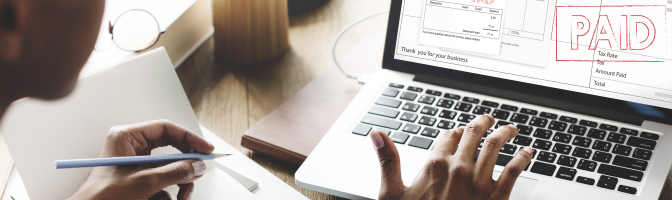 Woman working on computer looking at online invoice.