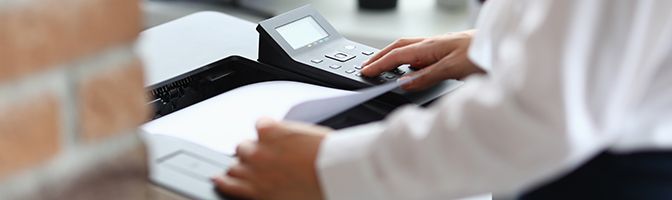 Closeup of business person using an office printer.