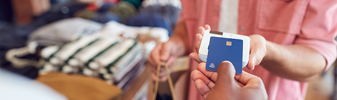 Close up of credit card used in contactless payment in a retail store.