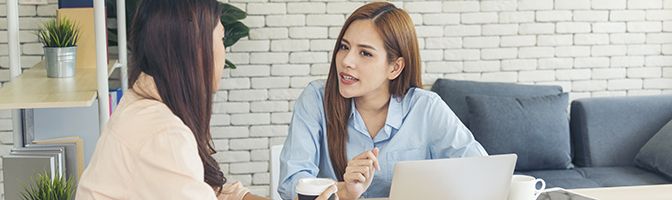 Two people talking in an office setting.