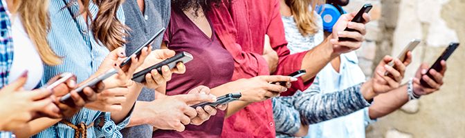 A group of people looking at their smartphones.