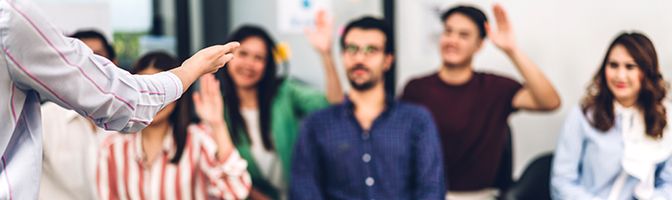 A small business owner leads a discussion with their employees.