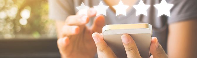 Five stars superimposed over a person holding a smart phone.