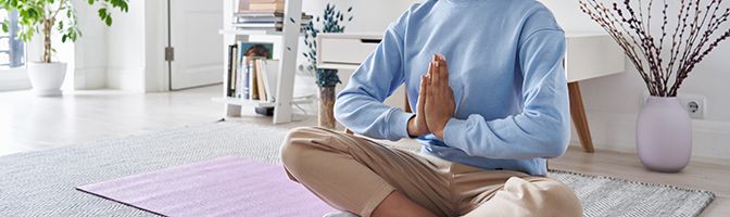 A person meditating on a yoga mat.