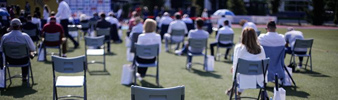 Outdoor event with people gathered while social distancing.