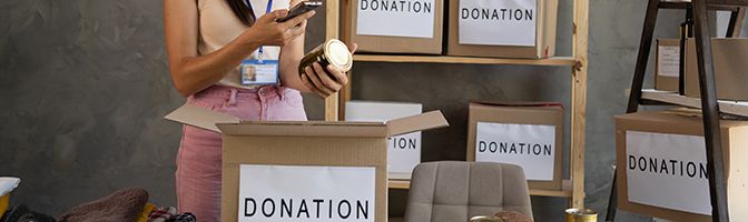 A person stands surrounded by boxes labeled with 'donation'.