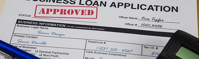 Business loan application shown with a red "Approved" stamp.
