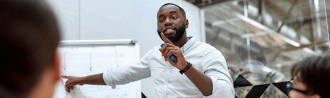 A business professional gives a presentation during a meeting.