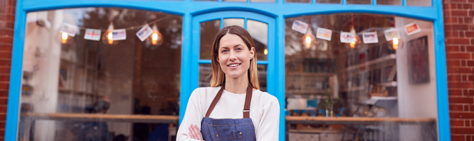 Portrait Of Smiling Female Small Business Owner Standing Outside Shop On Local Street