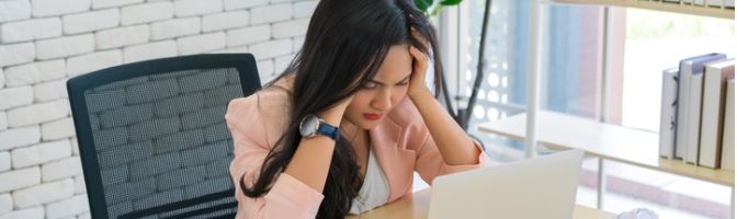 Stressed small business owner sitting in front of a laptop 