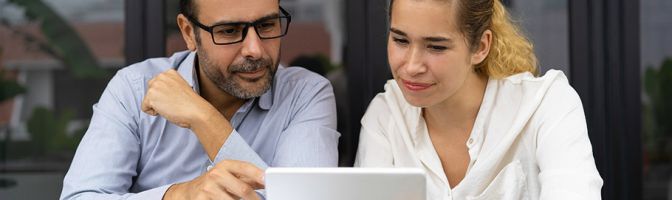 man and woman looking at a tablet