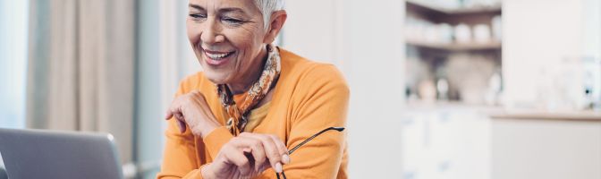 senior woman smiling at laptop