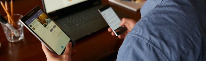 closeup of man looking at tablet and phone