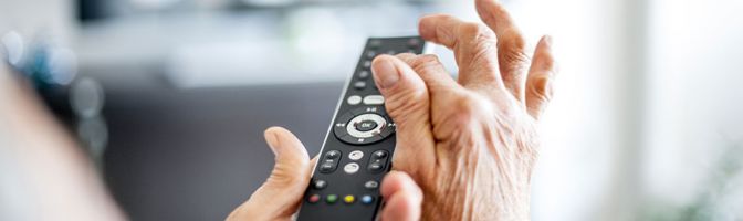 close up of a person using a tv remote