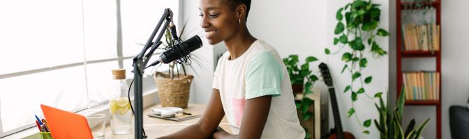 woman recording podcast on laptop with mic