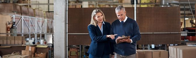 man and woman discussing something in a warehouse