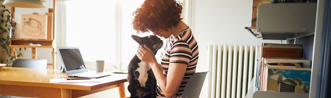 Woman holding dog at home office