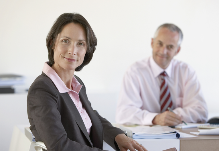 Portrait of businesswoman with male colleague in office