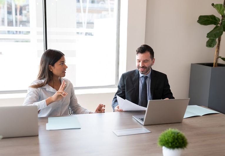 Two business people sitting on office conference room and discussing work.