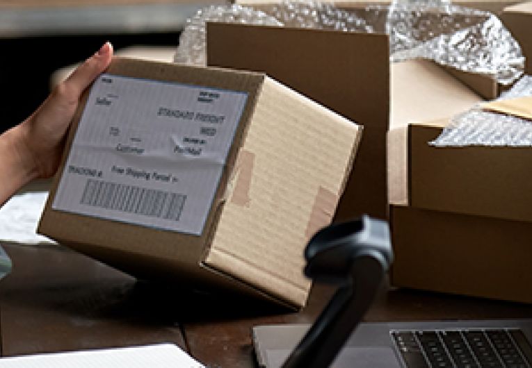 Entrepreneur scans label on box that is ready to ship for online business.