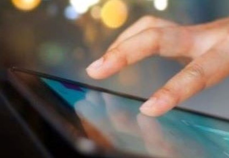 Closeup of a hand scrolling through a digital tablet