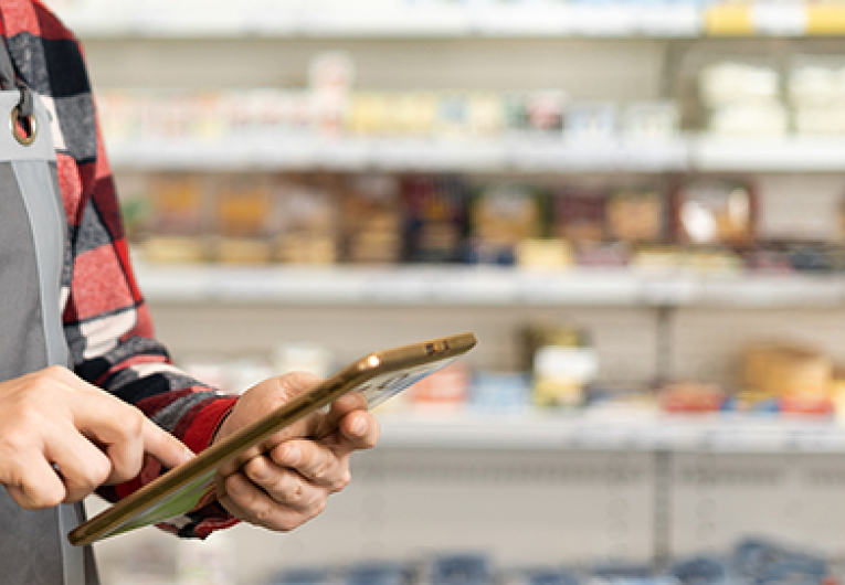 supermarket clerk using apps on a digital tablet