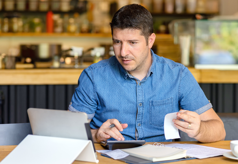 Mature small business owner calculating finance bills of activity