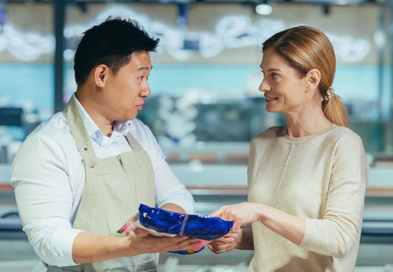 a male consultant in a local grocery store advises a female customer about product