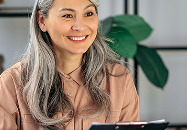 Mature businesswoman examines the resume of a female job seeker, sitting in office.
