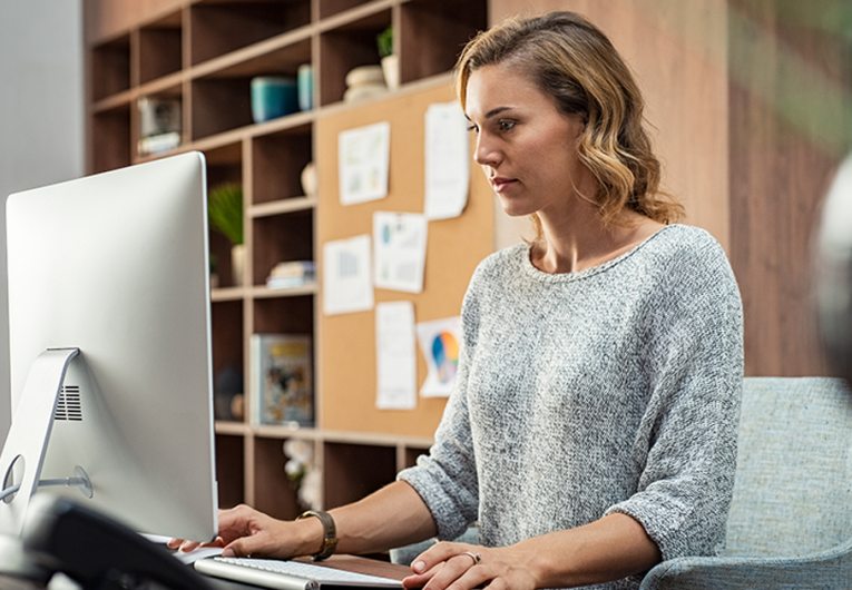 Mature businesswoman working on desktop computer at modern office.