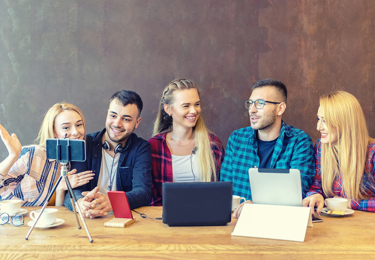 Five young men and women sharing content on streaming platform with digital web camera