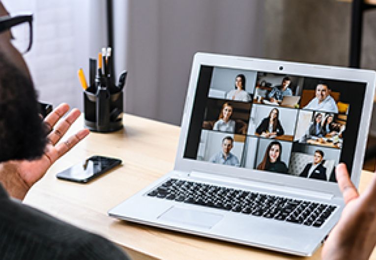 An entrepreneur gives a virtual talk to a group of small business owner through a video conference.