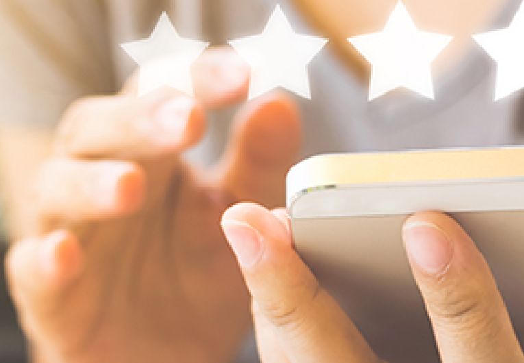 Five stars superimposed over a person holding a smart phone.