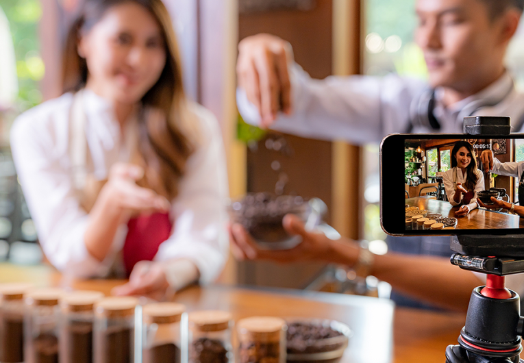 coffee shop owner recording video on smartphone for social media. 