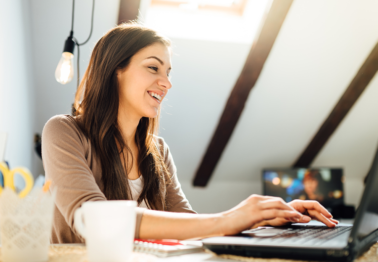 Business woman working on laptop computer in office.