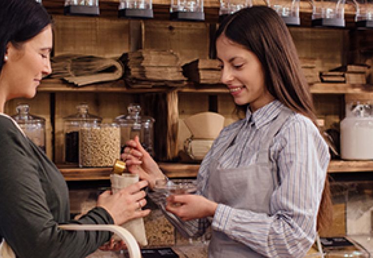 A small business owner shows product to a potential customer.