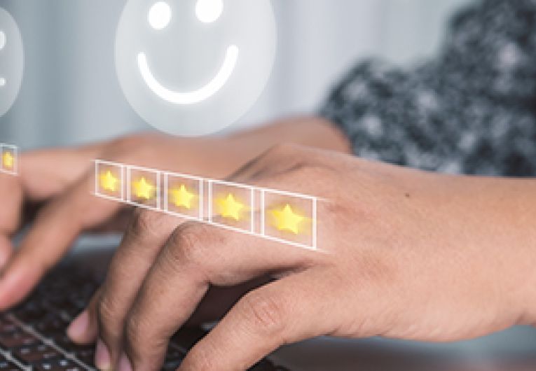 customer role in service delivery case study Ratings icon over a person typing on a laptop.