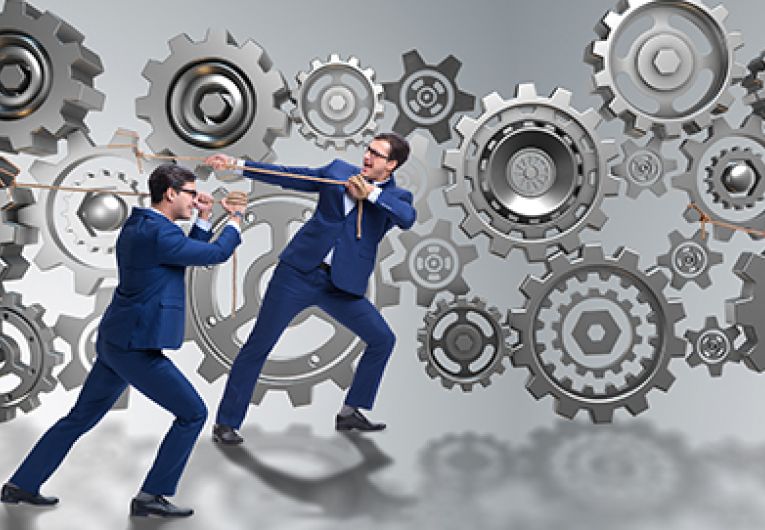 business people tug-of-war with gears and cogs
